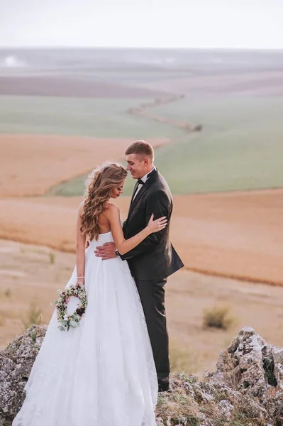 Krásné Svatební Pár Pózuje Horách Nevěsta Drží Věnec — Stock fotografie