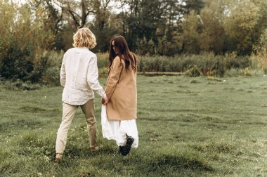 güzel genç çift güneşli ormanda yürüyüş boho tarzı giyinmiş