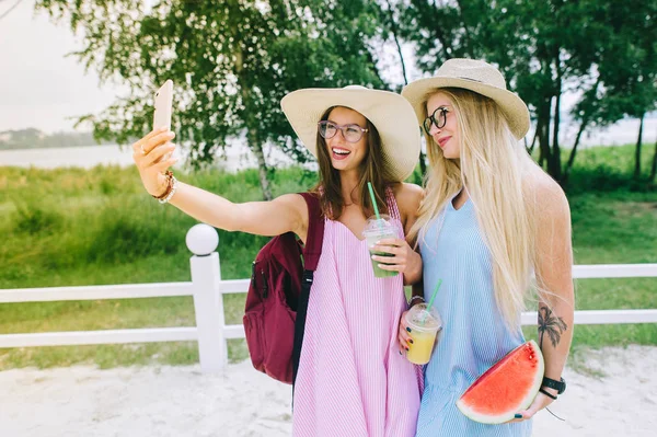 Twee Gelukkige Meisjes Drinken Van Sap Het Maken Van Selfie — Stockfoto