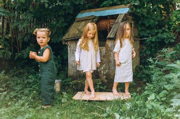 Drei Niedliche Kinder Spielen Der Nähe Des Brunnens Auf Einem — Stockfoto
