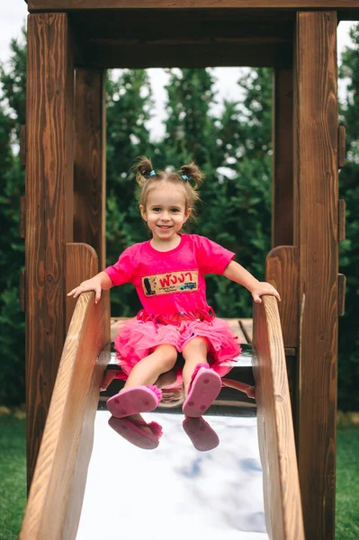 Cute Little Girl Descends Wooden Children Slide — Stock Photo, Image