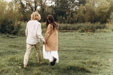 güzel genç çift güneşli ormanda yürüyüş boho tarzı giyinmiş