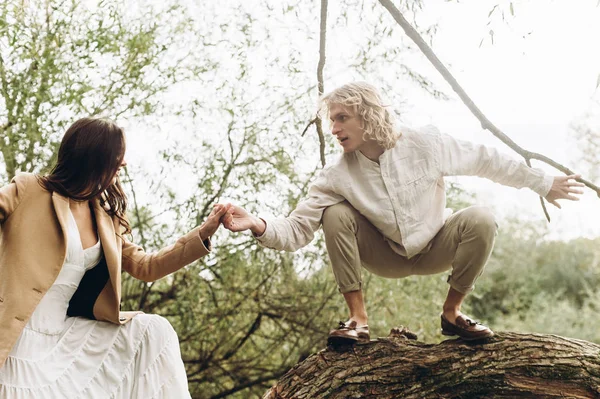 美丽的年轻夫妇在嘘的风格拥抱坐在一个树枝上的湖 — 图库照片