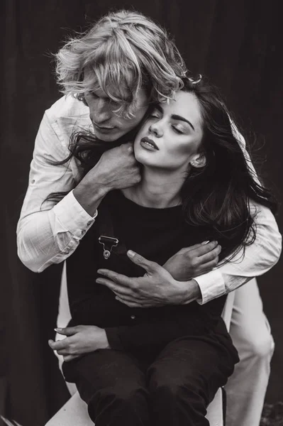 beautiful young  couple on a black background is full of emotions