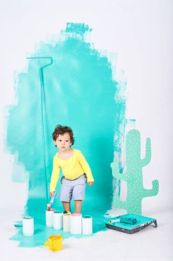 Sevimli küçük çocuk onarım daire eğlenceli yapıyor duvar boyaları 