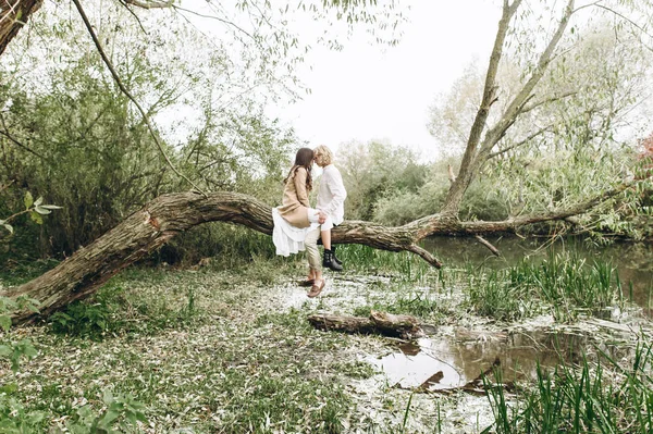 美丽的年轻夫妇在嘘的风格坐在大树的树枝上 — 图库照片