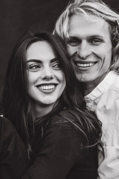 beautiful young  couple on a black background is full of emotions