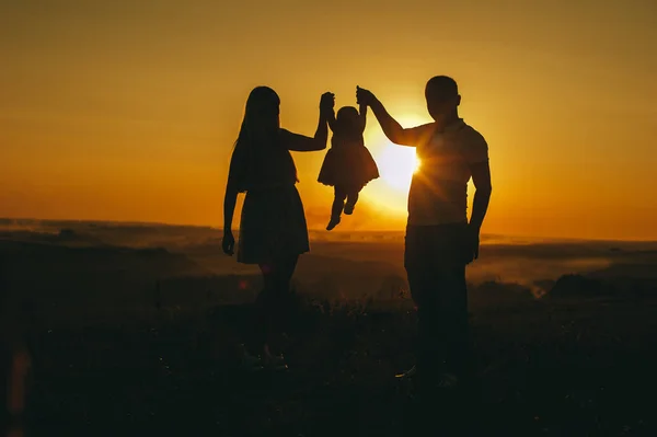Father mother and daughter admire the sunset