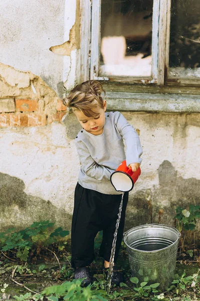 Little Blond Boy Red Mug Bucket Background — Stock Photo, Image