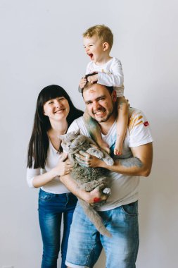 Genç aile evlat ve kedi ile oynadıktan sonra beyaz bir arka plan üzerine boyar