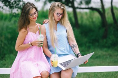 Suyu içme ve dizüstü bilgisayarda çalışan iki kız