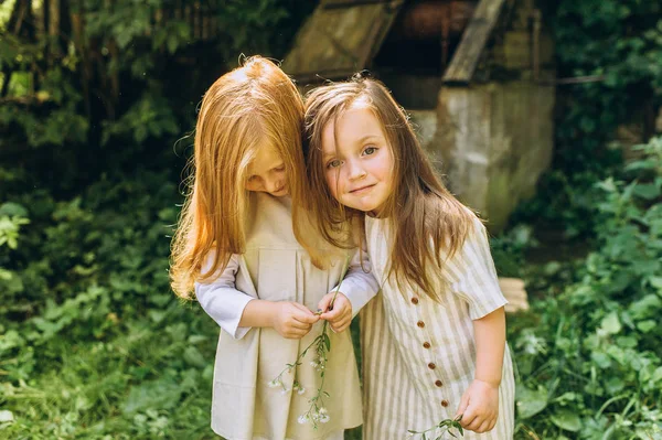 两个漂亮的女孩在古董衬衫附近的井 — 图库照片