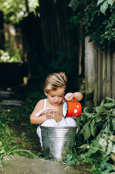 Little Blond Boy Red Mug Bucket Background — Stock Photo, Image