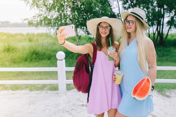 Δύο Κορίτσια Ευτυχισμένη Πίνοντας Χυμό Και Καθιστώντας Selfie — Φωτογραφία Αρχείου