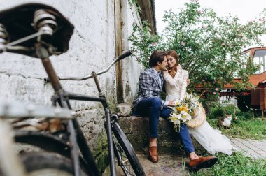 Güzel genç bir çift, gelin ve damat, yaşlı bir bisikletin yanında.