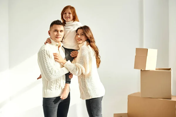 白い背もたれの新しい家で段ボール箱をアンパックする家族 — ストック写真