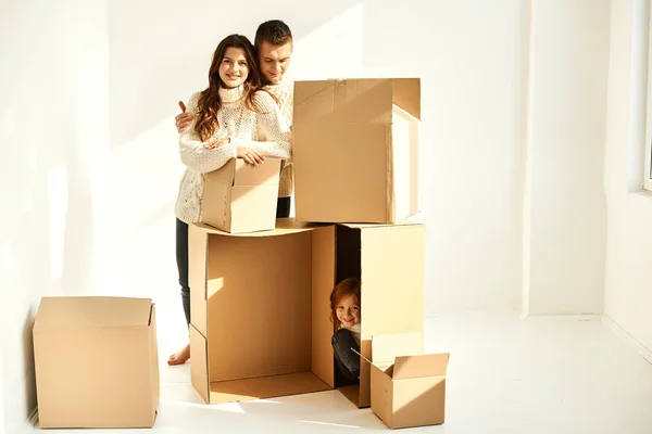 Família desempacotar caixas de papelão em nova casa em um backgrou branco — Fotografia de Stock