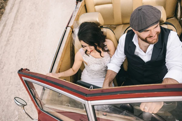 Casal de casamento elegante, noiva, noivo beijando no carro retro . — Fotografia de Stock