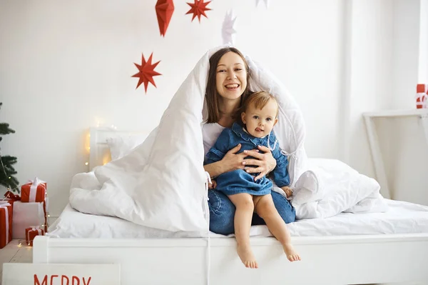 Retrato de madre feliz y su niña en la cama en casa con d —  Fotos de Stock