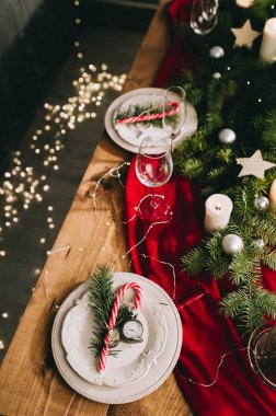 Yanan mumlar ve Noel süslemeleri olan şık bir masa.
