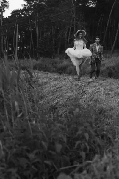 Una joven pareja de novias caminando en el bosque de pinos —  Fotos de Stock