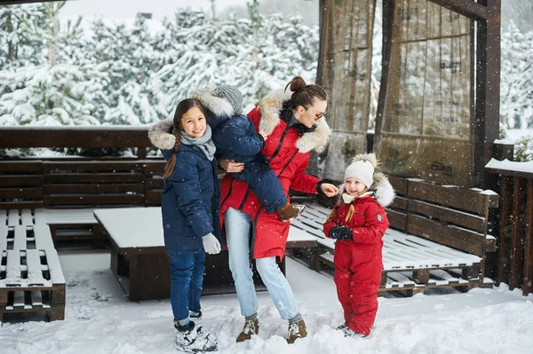 Eine junge Mutter mit ihren drei Kindern hat Spaß und spielt sno — Stockfoto