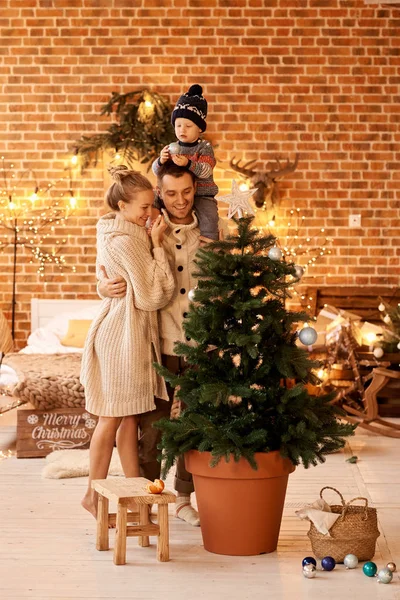 幸せな若い家族の寝室はクリスマスツリーを飾る — ストック写真