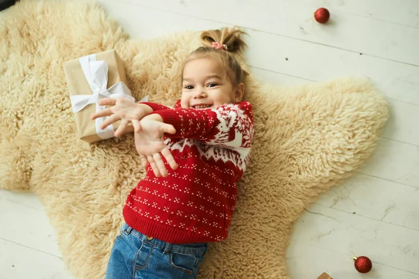 Porträt eines schönen kleinen Mädchens im roten Weihnachtspullover — Stockfoto