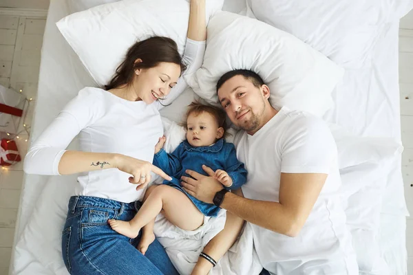 Feliz familia madre padre e hijo en la mañana de Navidad en la cama — Foto de Stock