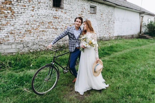 Una hermosa pareja joven novia y novio con una bicicleta cerca de edad —  Fotos de Stock