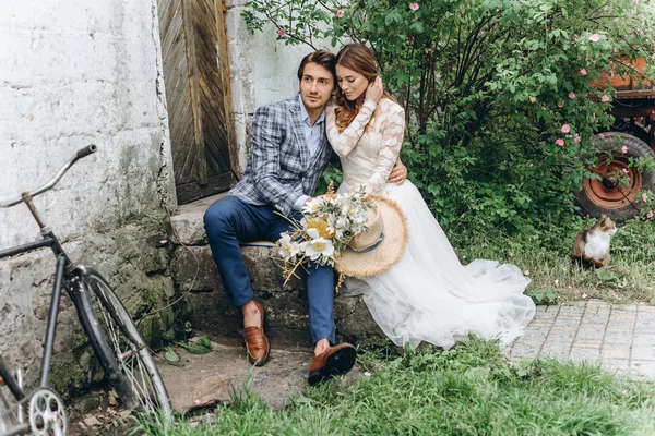 Um belo casal jovem noiva e noivo com uma bicicleta perto de idade — Fotografia de Stock