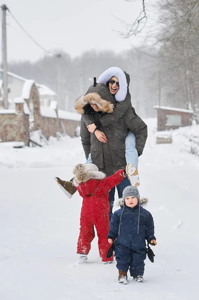 Szczęśliwa rodzina bawić się na zewnątrz w pobliżu domu w zimie — Zdjęcie stockowe
