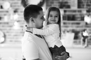 Küçük bir kız babasıyla eğleniyor ve oynuyor. 