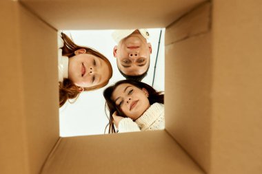 Aile, yeni evinde beyaz bir sırt çantasındaki karton kutuları açıyor.