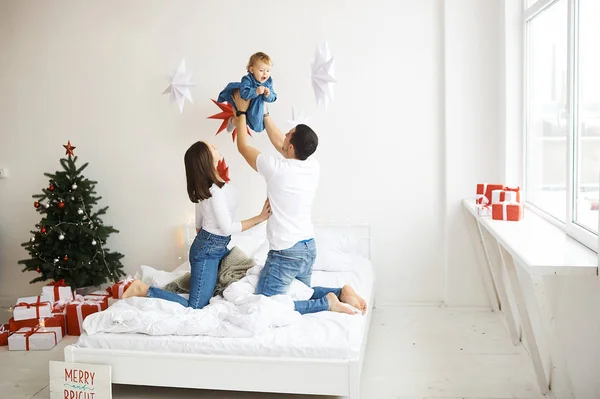 Mutlu aile anne baba ve çocuk Noel sabahı yatakta — Stok fotoğraf