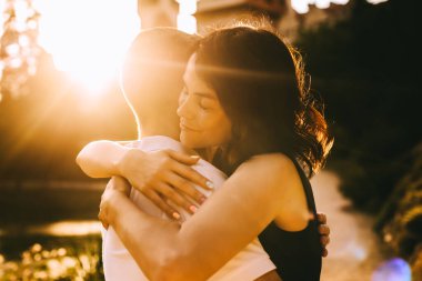 Yakışıklı genç baba ve güzel anne güneşli yaz doğasında sevimli küçük çocuklarıyla oynuyorlar.