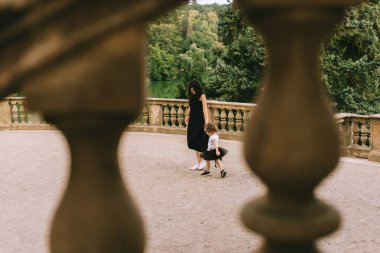 Yakışıklı genç baba ve güzel anne güneşli yaz doğasında sevimli küçük çocuklarıyla oynuyorlar.