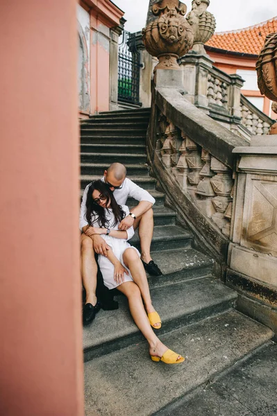 宮殿の中庭にある階段に座っている若い白人スタイリッシュなカップル — ストック写真