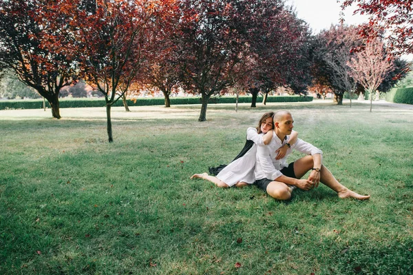 一对年轻的高加索风格的夫妇坐在美丽的公园里的小塔 — 图库照片