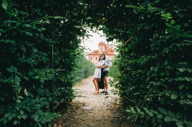 Kırmızı saray arka planında yeşil kemerlerle sarılan beyaz bir çift.
