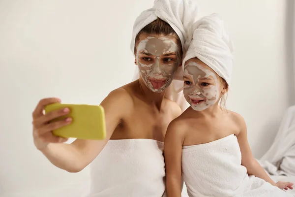 얼굴에 마스크를 수건으로 둘러싸인 둘러싸인 코카서스 어머니와 재미있게 전화로 셀카를 — 스톡 사진
