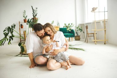 Evde çalışan mutlu bir aile. Çocuklarıyla birlikte bitkileri naklediyorlar.