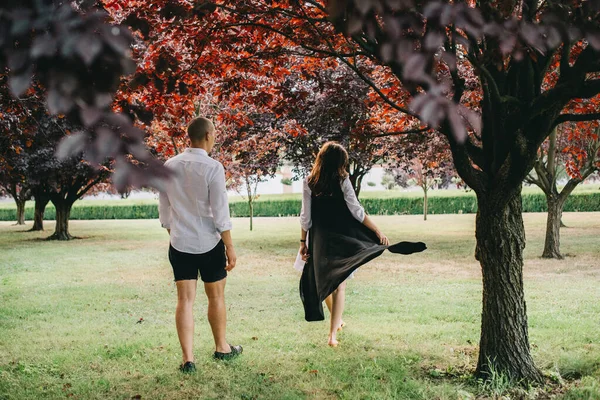 一对年轻的高加索风格的夫妇在美丽的公园里散步时的小塔 — 图库照片