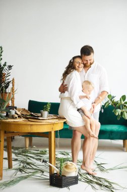 Evde çalışan mutlu bir aile. Çocuklarıyla birlikte bitkileri naklediyorlar.