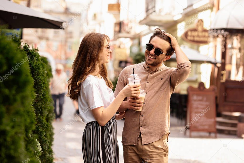 young beautiful couple have a fun and walking on city streets and drinking coffee