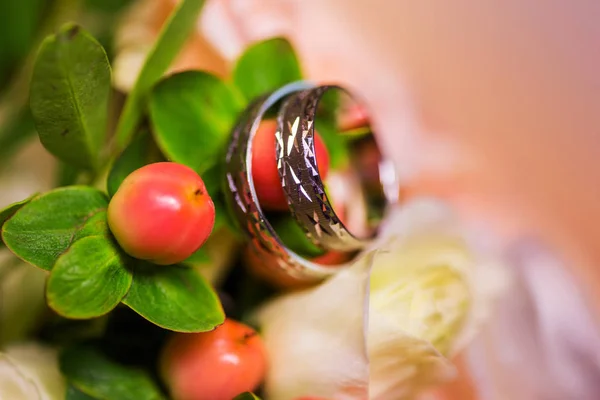 Hermosos anillos de boda dorados en las tiernas flores — Foto de Stock