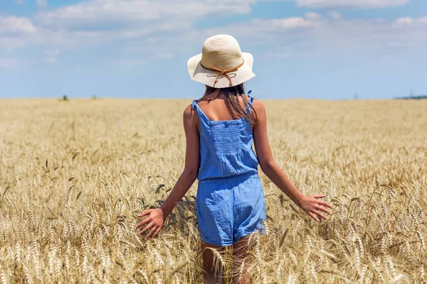 Mulher em um campo de trigo no fundo — Fotografia de Stock