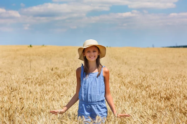 Mulher em um campo de trigo no fundo — Fotografia de Stock