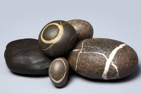 Set med randig stenar stenar på grå bakgrund — Stockfoto