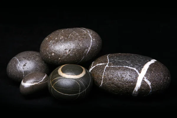 Set med randig stenar stenar på svart bakgrund — Stockfoto